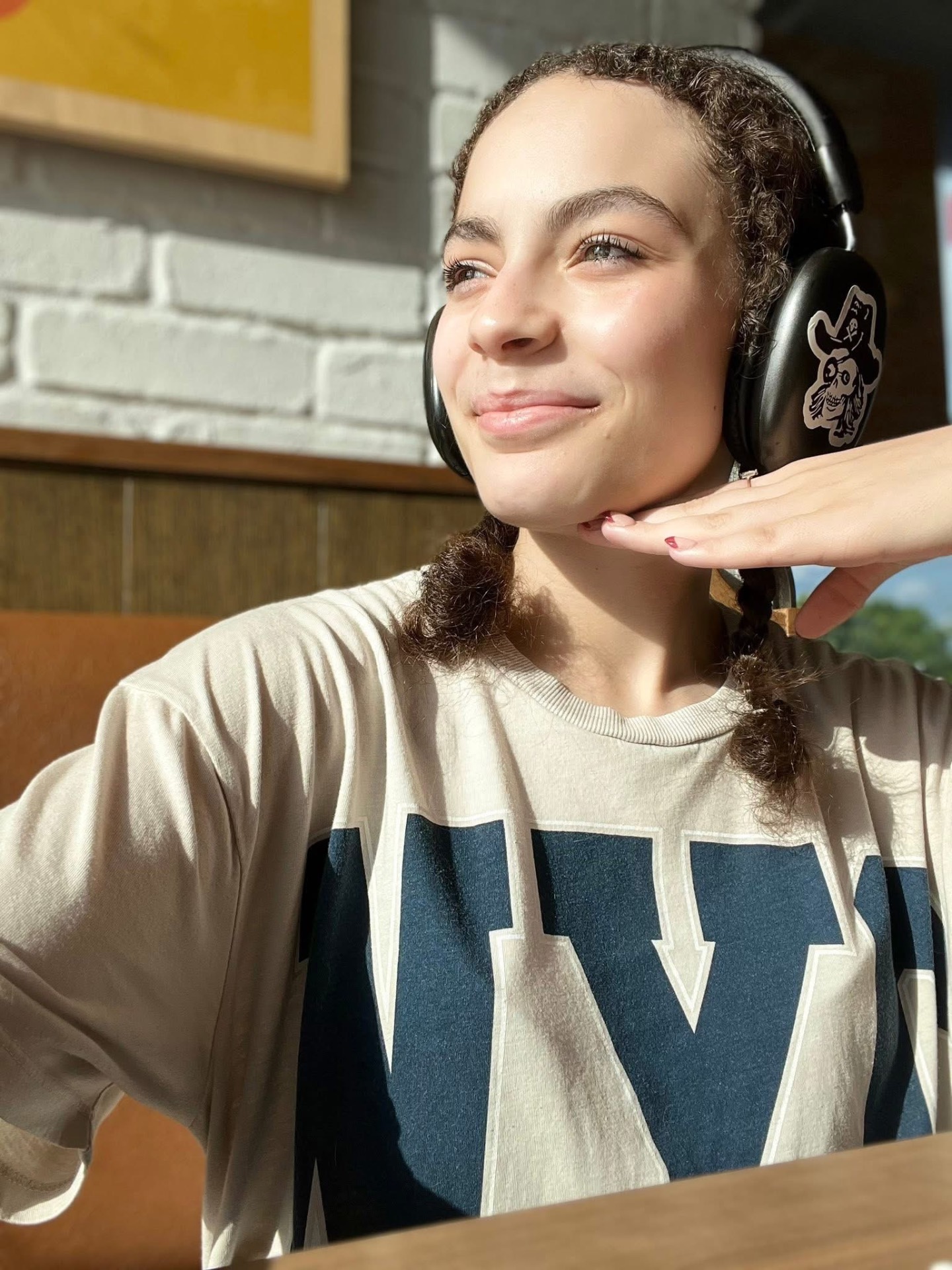 Brooklyn in headphones, sun-drenched and smiling